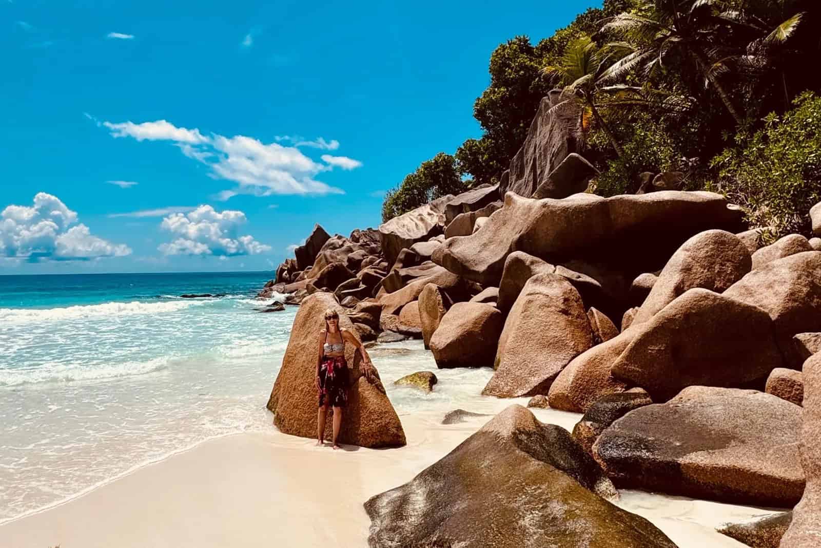 EN: Petite Anse, La Digue — remote wild cove with bright white sand and powerful surf | FR : Petite Anse, La Digue — crique isolée et sauvage au sable blanc avec houle puissante