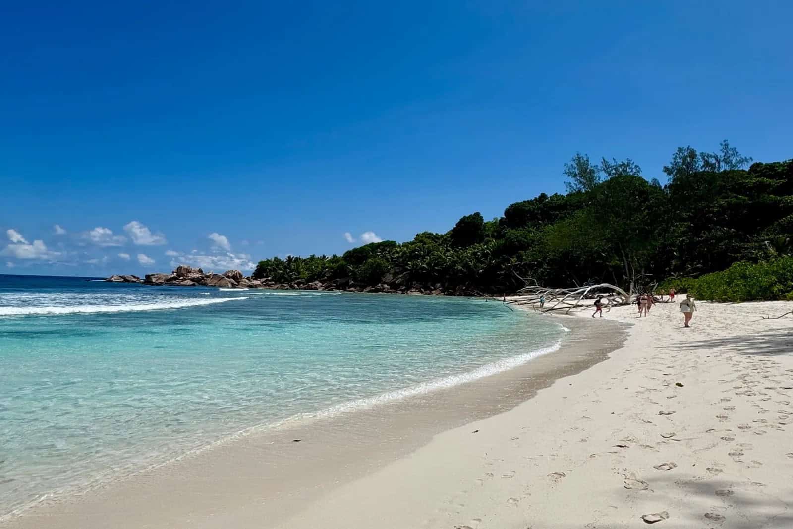 EN: Anse Cocos, La Digue — wild cove with natural rock pools and turquoise water (hike-in only) | FR : Anse Cocos, La Digue — crique sauvage avec bassins naturels et eau turquoise (accès à pied uniquement)