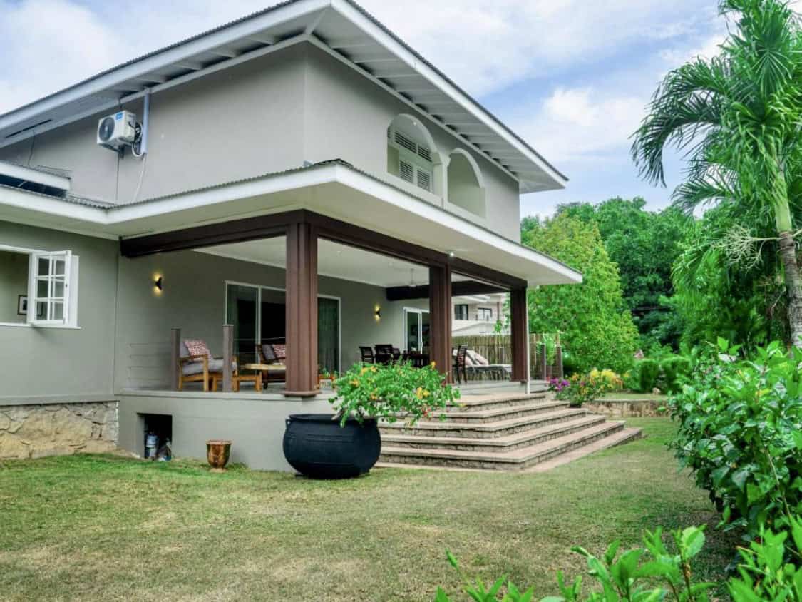 Jolie maison moderne avec terrasse et jardin vert à Seychelles.
